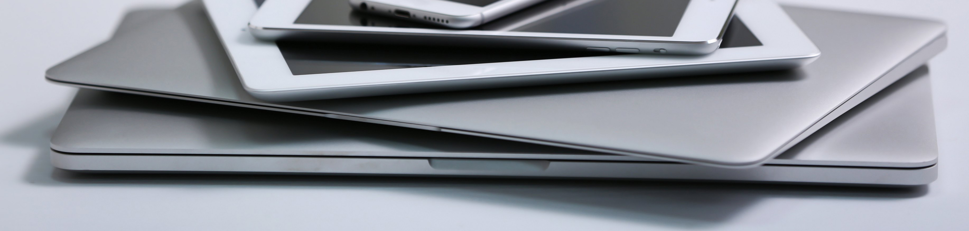 Stack of electronic devices on a white desk