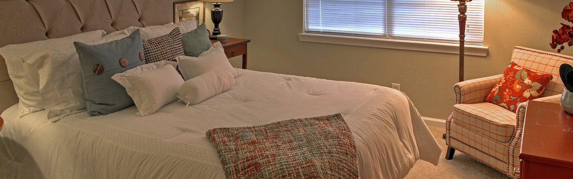 Westside Commons interior apartment. Spacious room with queen bed and night table