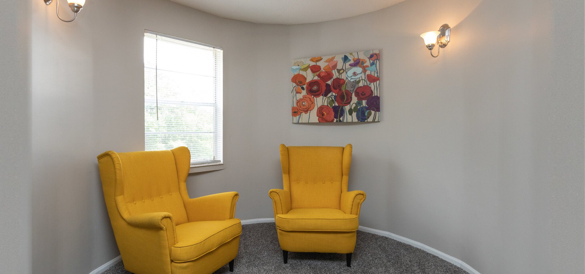 Westside Commons interior apartment. Living room with sofa, chairs and beautiful canvas paintings